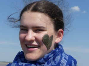 Porträt einer Frau mit einem aufgemalten Herz auf der Wange