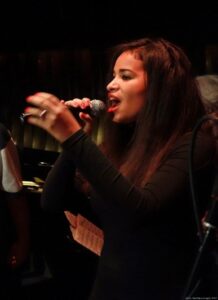 Eine Frau hält ein Mikro und singt